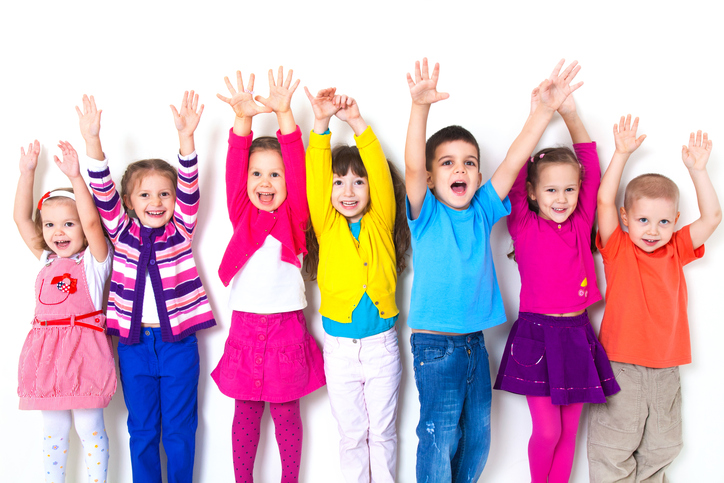 Seven kids in colorful clothing raising their both hands up